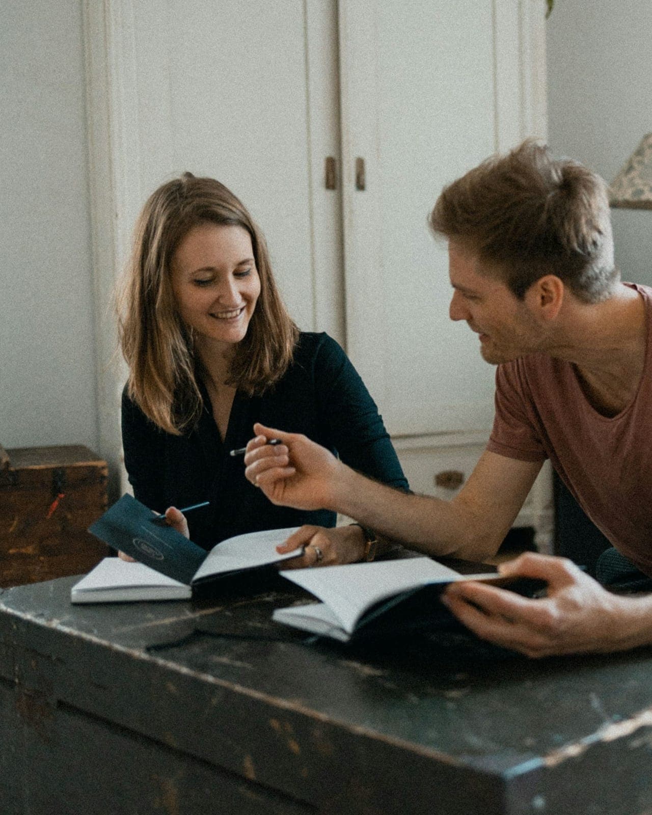 Two people write goals together in notebooks